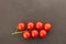 Juicy red tomato cherry branch horizontal fresh crop black background