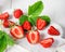 Juicy ripe tasty strawberries on  white cutting board on wooden table