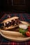 Juicy sandwich with roasted beef and mushrooms on a wooden board with white sauce and tomatoes