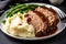 Juicy slices of homemade meatloaf topped with savory gravy and served with a side of creamy mashed potatoes and green beans