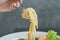 Juicy spaghetti in the fork and shrimp and vegetable on grey background. enjoy delicious lunch traditional italian food