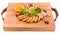 Juicy stewed duck breast in the company of turmeric with prunes, dried apricots and orange sauce on a wooden board on a white