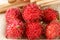 Juicy tropic red rambutan fruits group closeup on cane paper