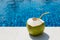 Juicy tropical coconut on blue pool background