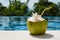 Juicy tropical coconut on blue pool background