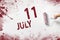 July 11st . Day 11 of month, Calendar date. The hand holds a roller with red paint and writes a calendar date on a white