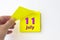 July 11st . Day 11 of month, Calendar date. Hand rips off the yellow sheet of the calendar. Summer month, day of the year concept