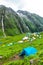 July 14th 2022, Himachal Pradesh India. Multiple colorful tents at Bheem Dwari base camp with beautiful mountains peaks and