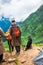 July 14th 2022, Himachal Pradesh India. People with a walking stick trekking down to Parvati bagh valley during Shrikhand Mahadev