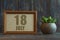 july 18th. Day 18 of month, date in frame next to succulent on wooden background summer month, day of the year concept