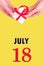 July 18th. Festive Vertical Calendar With Hands Holding White Gift Box With Red Ribbon And Calendar Date
