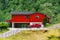 July 20, 2019. Norway. Flam. Red wooden house and cars in Norwegian Flam town. Country house and car on the yard