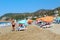 July, 2017 - People rest on deckchairs in the shade of beach umbrellas on Cleopatra Beach Alanya, Turkey