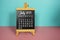 July 2023 monthly calendar on easel stand on pink and blue background