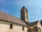 July 21, 2017. France. Region Burgundy. An old stone church with a tower, a bell tower on which is a cross and a rooster, next to