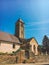 July 21, 2017. France. Region Burgundy. An old stone church with a tower, a bell tower on which is a cross and a rooster, next to