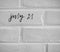 July 21 WRITTEN ON WHITE PLAIN BRICK WALL