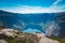 July 26, 2019. Norway. man dreamer lying on stone, relaxing after hiking on cliff mountain top with blue water fjord on