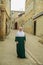 July 29, 2023. Russia, Republic of Dagestan, Derbent, a Muslim woman in a green dress and a white khimar on the street