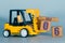 july 6th. Day 6 of month, Construction or warehouse calendar. Yellow toy forklift load wood cubes with date. Work planning and