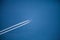 Jumbo Jet in dizzy height with two white condensation trails