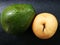 Jumbo sized ripe avocado adn pear on black leather board