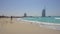 Jumeirah beach, Sunny day, people relax, swim, in the background hotel Burj al Arab.