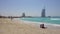 Jumeirah beach, Sunny day, people relax, swim, in the background hotel Burj al Arab, the Persian Gulf.