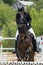 Jump of the horse through the barrier with the rider during the competition