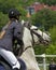 Jump of the horse through the barrier with the rider during the competition