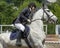 Jump of the horse through the barrier with the rider during the competition