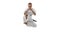 In a jump. Portrait of one caucasian sportsman training isolated over white background. Karate, judo, taekwondo sport