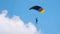 jump with a tandem colored parachute on a blue sky with white clouds