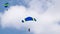 Jump with a tandem colored parachute on a blue sky with white clouds, adrenaline and risk
