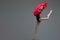 Jumping ballerina in tutu holding red silk