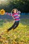 Jumping girl with autumn leaves