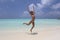 Jumping girl in the white Maldivian beach