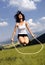 Jumping rope attractive women in meadow