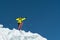 A jumping skier jumping from a glacier against a blue sky high in the mountains. Professional skiing