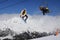 A jumping snowboarder in the mountains. Snowboarding, winter extreme sport.