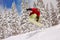 Jumping snowboarder on snowboard in mountains in ski resort