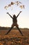 Jumping teenage girl, throwing leaves up in the air