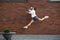 Jumping young man in front of buildings, on the run in jump high