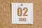 june 02. 02th day of the month, calendar date.White calendar sheet attached to brown cork board.Summer month, day of the