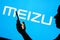 June 13, 2023, Brazil. Meizu logo is seen in the background of a silhouetted woman holding a