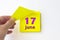 June 17th. Day 17 of month, Calendar date. Hand rips off the yellow sheet of the calendar. Summer month, day of the year concept