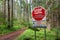 June 2022 - Nanaimo, Canada: No Dumping sign and hiking trail in green forest.