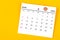 A June 2023 calendar and wooden push pin on yellow background