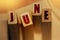 June word on wooden blocks with letters. Month events or important dates concept