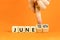 Juneteenth in June symbol. Concept words Juneteenth and June on wooden cubes. Beautiful orange table orange background.